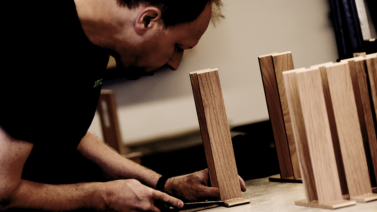 Mitarbeiter montiert Besteckeinsätze aus Holz